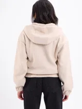 Campera de paño color beige con capucha, cierre frontal completo y mangas largas con puños elásticos. Presenta un diseño corto con ruedo elástico.