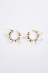 Aros tipo argolla de metal dorado decorados con pequeñas cuentas en tonos verdes y caracoles naturales colgantes.