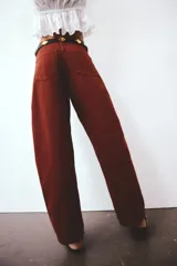 Jeans de corte baggy y tiro alto confeccionados en denim de algodón rígido, con diseño de cinco bolsillos, piernas amplias y cierre frontal con botón y cremallera.