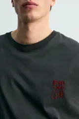 Musculosa de corte relajado en color negro con efecto lavado. Presenta cuello redondo, sisas amplias con acabado irregular y estampado gráfico de Jurassic Park en el frente y la espalda.