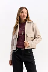 Campera corta de paño color negro, con cierre frontal metálico, cuello camisero y bolsillos frontales con solapa y botón metálico.