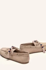 Mocasín estilo náutico de gamuza marrón, con cordones de cuero, borla decorativa y cuentas de colores en el empeine.