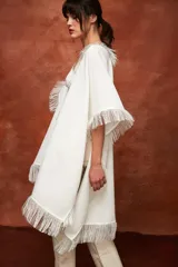 Chal de tejido liviano con lino, color blanco, con terminaciones desflecadas y diseño versátil para usar como capa.
