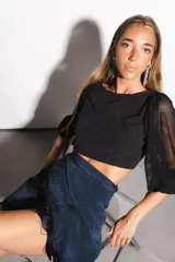 Minifalda azul con brillos, corte pareo y flecos negros en el ruedo.