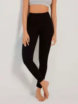 Calza larga negra de tejido de punto, con puño en los tobillos.