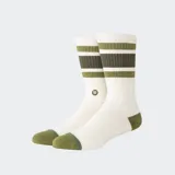 Medias de caña media Stance modelo Boyd, color blanco con detalles en verde oliva en la puntera, el talón y la parte superior. Presentan diseño de rayas horizontales en la caña y logo bordado pequeño.