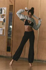 Pantalón deportivo negro de tejido liso, corte acampanado o 'bootcut' con dobladillo en forma de curva que realza la silueta.