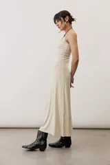 Vestido largo color verde suave, sin mangas, con escote redondo y silueta al cuerpo que se ensancha levemente hacia el dobladillo.