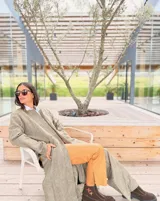 Tapado largo de paño liviano con diseño de cuadros en tonos marrones. Presenta solapas clásicas, bolsillos laterales con detalles en cuero y tajos profundos en los costados.