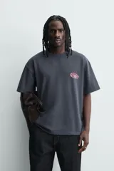 Remera de algodón con efecto lavado, corte relajado, cuello redondo y manga corta. Presenta un gráfico estampado en el pecho con la inscripción Posty Co.