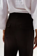 Pantalón de vestir color camel, tiro alto, corte recto y ancho, con puños doblados en el ruedo.