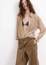 Pantalón marrón de corte recto, con cintura ajustable elastizada y cordón, y detalle de franja lateral bordada con diseño calado.