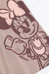 Remera de manga corta color gris topo con diseño oversize, cuello redondo y estampado grande de Minnie Mouse tomándose una selfie en tonos marrón oscuro y rosado.