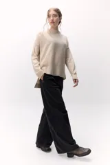 Sweater de lana color crema, de cuello alto y corte holgado.