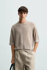 Camiseta color beige de punto tejido en hilatura de lino, con cuello redondo, manga corta y acabados en rib.