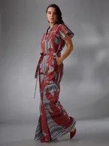 Mono de lino mezcla con estampado vegetal en tonos rojos, grises y blancos, de manga corta, escote en V y piernas amplias con cinto incorporado para ajustar la cintura.