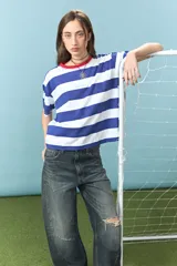 Remera de algodón con diseño de rayas horizontales azules y blancas, cuello redondo en color rojo con detalle de costura en zigzag y bordado frontal con la palabra Yorugua.