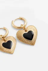 Aros colgantes dorados con dije en forma de corazón texturizado y centro negro.