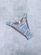 Bombacha de bikini vedetina celeste con estampado abstracto en blanco y forro color piel.