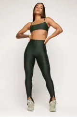Calza larga de lycra color verde oscuro, de cintura alta y corte ajustado, con costura frontal y aberturas en los tobillos.
