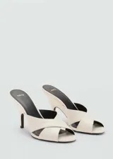 Sandalias de tacón alto tipo embudo color beige, con diseño de tiras cruzadas en el empeine y puntera abierta.