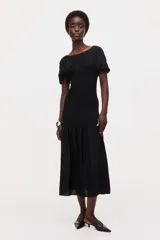 Vestido midi negro con escote bote, mangas cortas y cuerpo con sección fruncida elástica hasta las caderas, con falda evasé fluida.