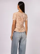 Remera de manga corta Calvin Klein con estampado animal print en tonos marrones y blancos. Presenta un corte regular y cuello redondo clásico.