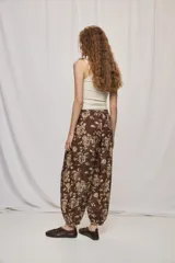 Pantalón de tiro alto y silueta amplia con estampado floral, pinzas en el frente, volumen relajado y terminación elastizada en los tobillos.