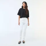 Pantalón jean blanco de corte super skinny, tiro alto con cierre de múltiples botones visibles y confeccionado en tejido elastizado.