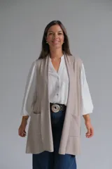 Chaleco largo abierto de tejido de punto, color visón, con bolsillos frontales aplicados y diseño sin mangas.