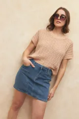 Minifalda de jean color beige claro, con corte en A y bolsillos delanteros curvos.