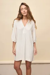 Vestido corto negro de silueta relajada, con escote en V y mangas 3/4 levemente abullonadas.