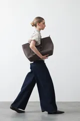 Camisa de manga corta abullonada, con cuello camisero y botones frontales. Presenta un estampado de inspiración barroca en tonos marrón y beige claro.