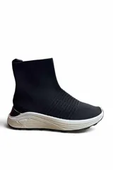 Bota deportiva Paddock Knicks tipo botineta tejida estilo media, color negro con suela blanca estructurada.