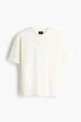 Remera de corte holgado confeccionada en punto interlock de algodón, con cuello redondo acanalado, hombros caídos y bajo recto.