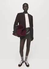 Bolso tipo shopper de piel de serraje en color bordó, con diseño estructurado, doble asa de hombro y cierre de botón magnético. Incluye forro interior de algodón y bolsillo con cierre de cremallera.
