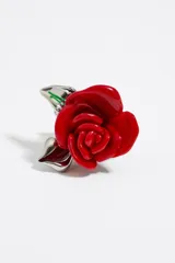 Anillo de metal plateado con forma de rosa roja de resina y hojas plateadas.