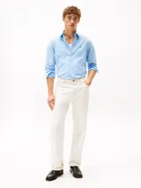 Camisa celeste de algodón Oxford con corte regular y mangas largas. Tiene cuello abotonado, cierre con botones y logo de Tommy Hilfiger bordado en el pecho.