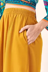 Pantalón de mujer color mostaza, de corte palazzo, tiro alto y cintura elástica.