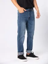 Jean de corte slim fit con cintura media, confeccionado en denim azul con efecto lavado y costuras en contraste.