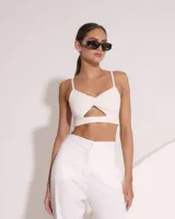 Top blanco con breteles finos, fruncido en el centro y abertura en el abdomen.