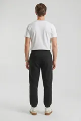 Pantalón de jogging unisex color negro, con cintura elástica y puños acanalados en los tobillos. Presenta un corte cómodo y bolsillos laterales.