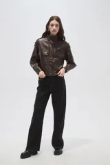 Campera de eco-cuero color marrón oscuro, con cuello alto, cierre frontal, bolsillos delanteros con solapa y detalles de charreteras en los hombros.