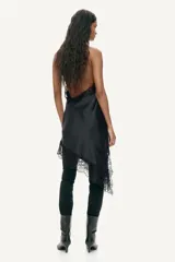 Vestido corto de satén color negro, con escote drapeado, espalda descubierta y breteles halter de encaje. Presenta bajo asimétrico con detalles de encaje.