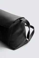 Bolso tipo bandolera de piel con acabado grabado, diseño rectangular con solapa frontal y cierre magnético. Cuenta con un asa de hombro ajustable y compartimento interior con cierre de cremallera.