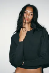 Jersey de punto liso con cuello redondo y manga larga, de corte recto y diseño minimalista.