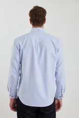 Camisa de vestir blanca de manga larga, con cuello abotonado, bolsillo frontal y botones en tono madera.