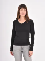 Remera de manga larga color negro, con escote en V y corte ajustado al cuerpo.