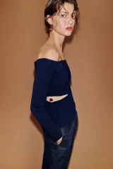 Top de punto de manga larga con escote barco, diseño ajustado y aberturas laterales decoradas con abalorios.