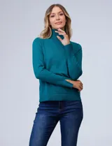 Polera de tejido fino, color rosado, con cuello alto, manga larga y detalle de tajo en los puños.